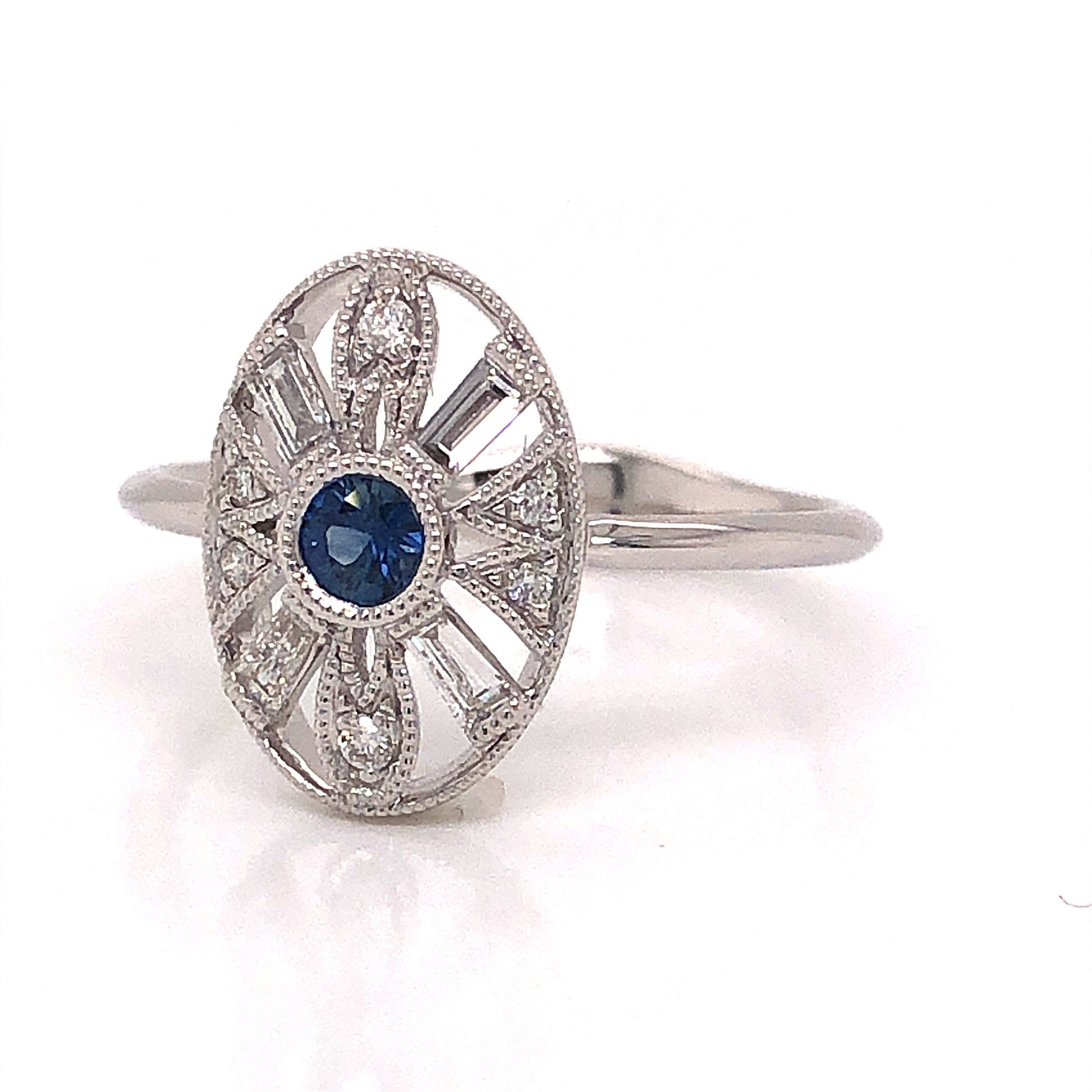 Art Deco Inspired Sapphire & Diamond Ring in 18k White GoldComposition: 18 Karat White Gold Ring Size: 6.5 Total Diamond Weight: .19ct Total Gram Weight: 2.58 g Inscription: 18k
      