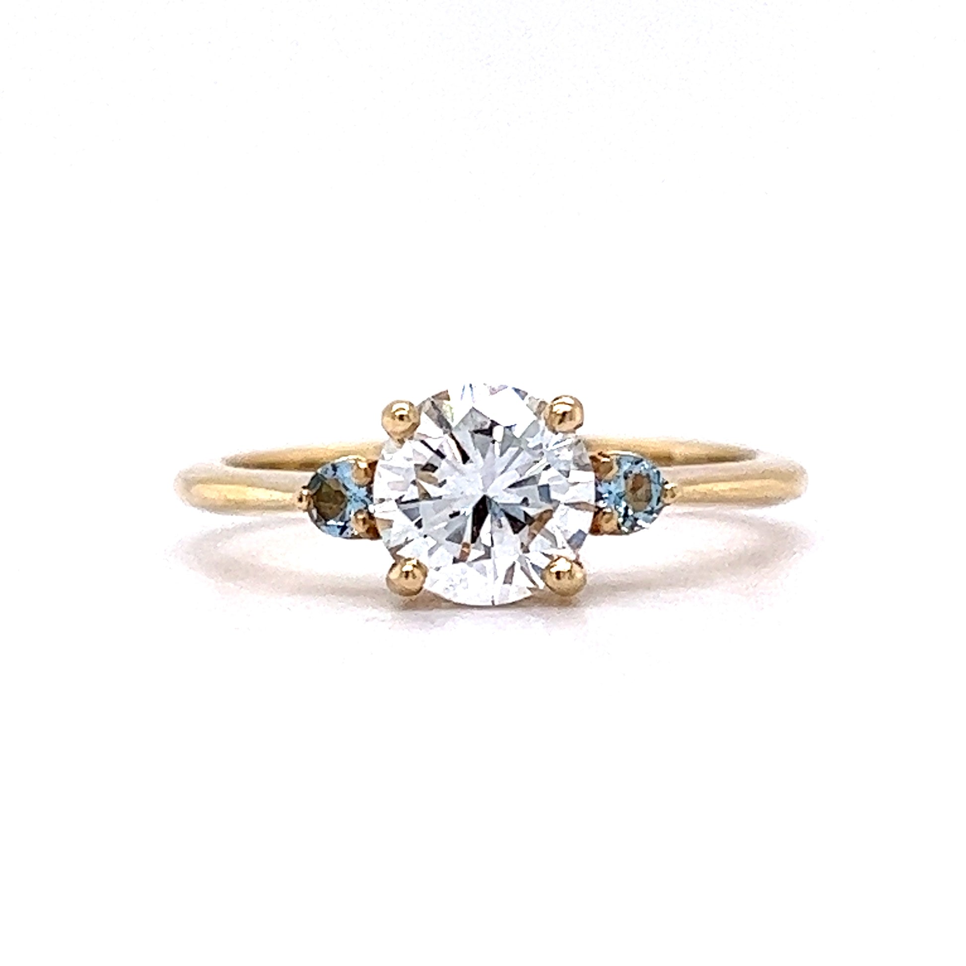 1.03 Round Diamond Engagement Ring w/ Aquamarine AccentsComposition: 14 Karat Yellow GoldRing Size: 7Total Diamond Weight: 1.03 ctTotal Gram Weight: 2.7 gInscription: 14k