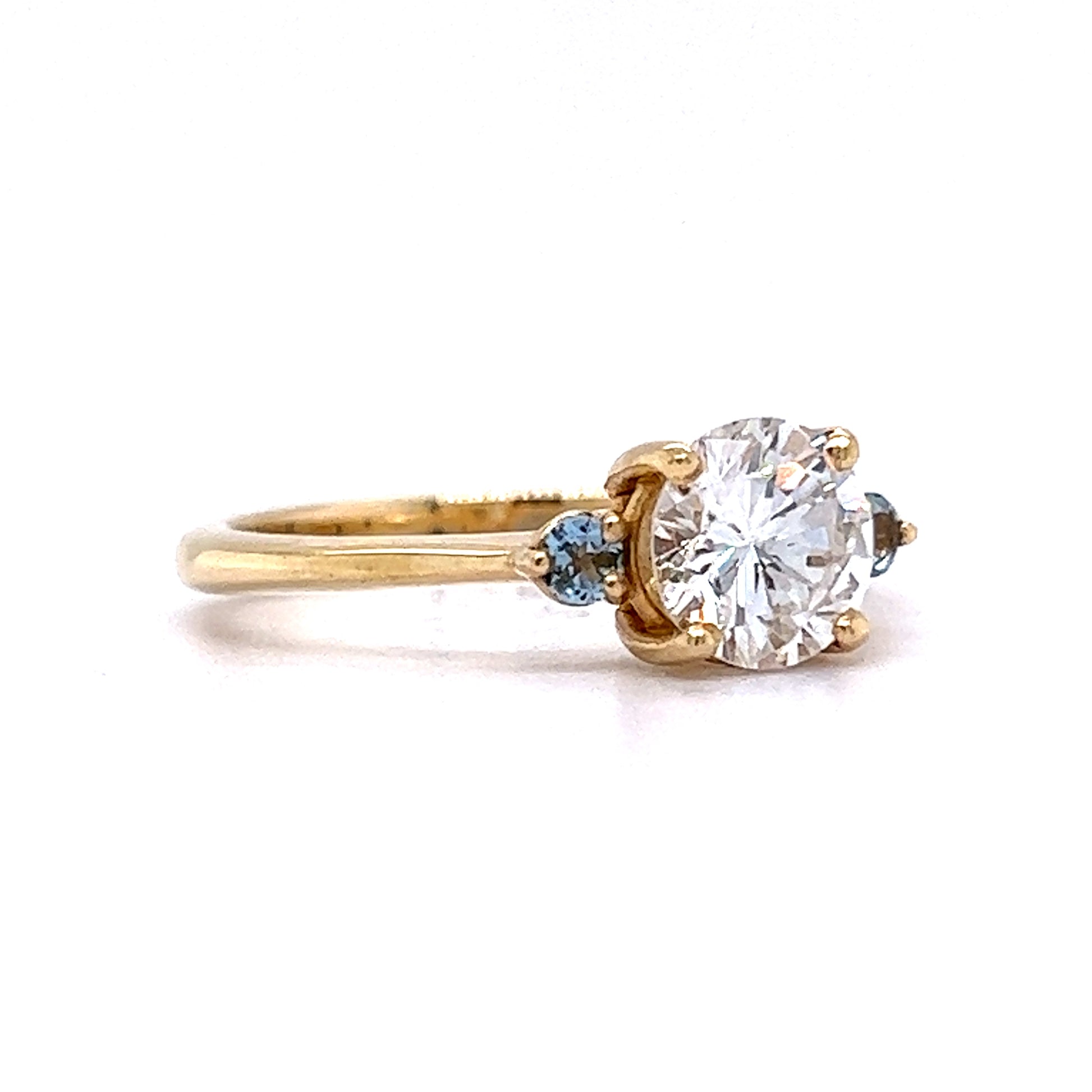 1.03 Round Diamond Engagement Ring w/ Aquamarine AccentsComposition: 14 Karat Yellow GoldRing Size: 7Total Diamond Weight: 1.03 ctTotal Gram Weight: 2.7 gInscription: 14k