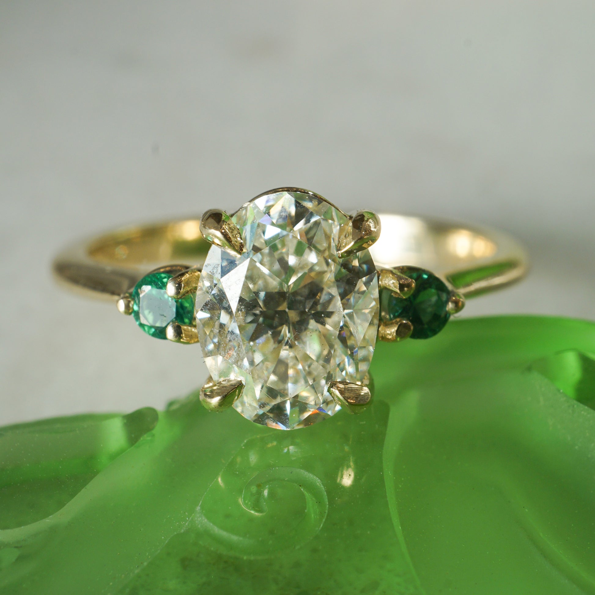 1.51 Oval Cut Diamond Engagement Ring w/ Emerald AccentsComposition: 14 Karat Yellow Gold Ring Size: 7 Total Diamond Weight: 1.51ct Total Gram Weight: 3.0 g Inscription: 14k
      